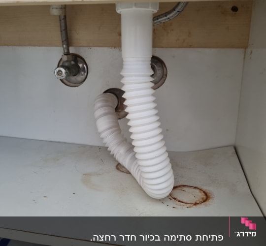 צינור פלסטיק מתחת לכיור עם חיבורים